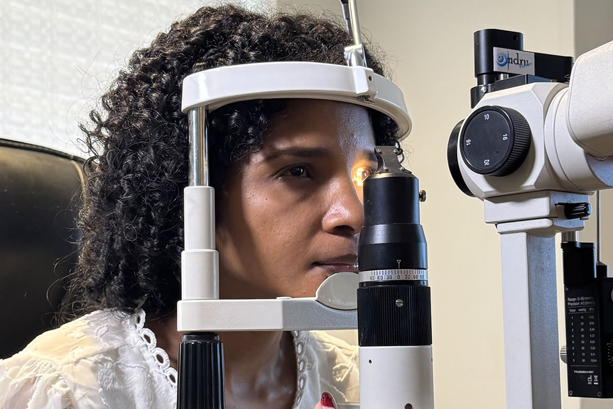 Paciente durante examen oftalmológico con lámpara de hendidura para diagnóstico de neuropatía óptica hereditaria de Leber (LHON).